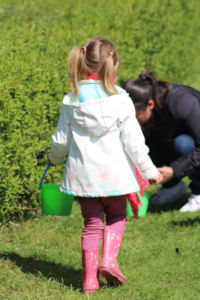 Petite fille avec son seau de carottes pour nourrir les animaux du Camélus